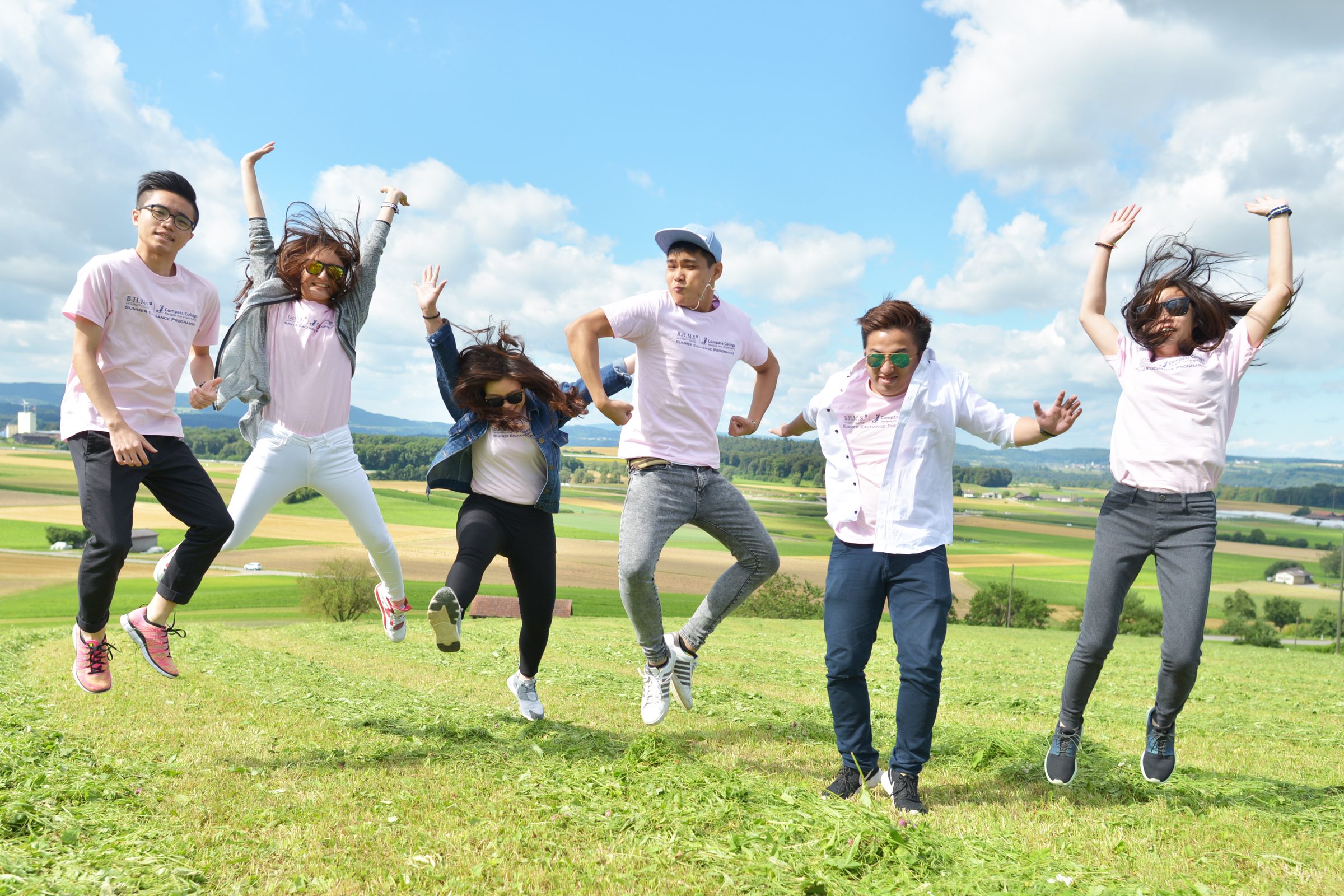 Camp group jumping in a Swiss meadow
